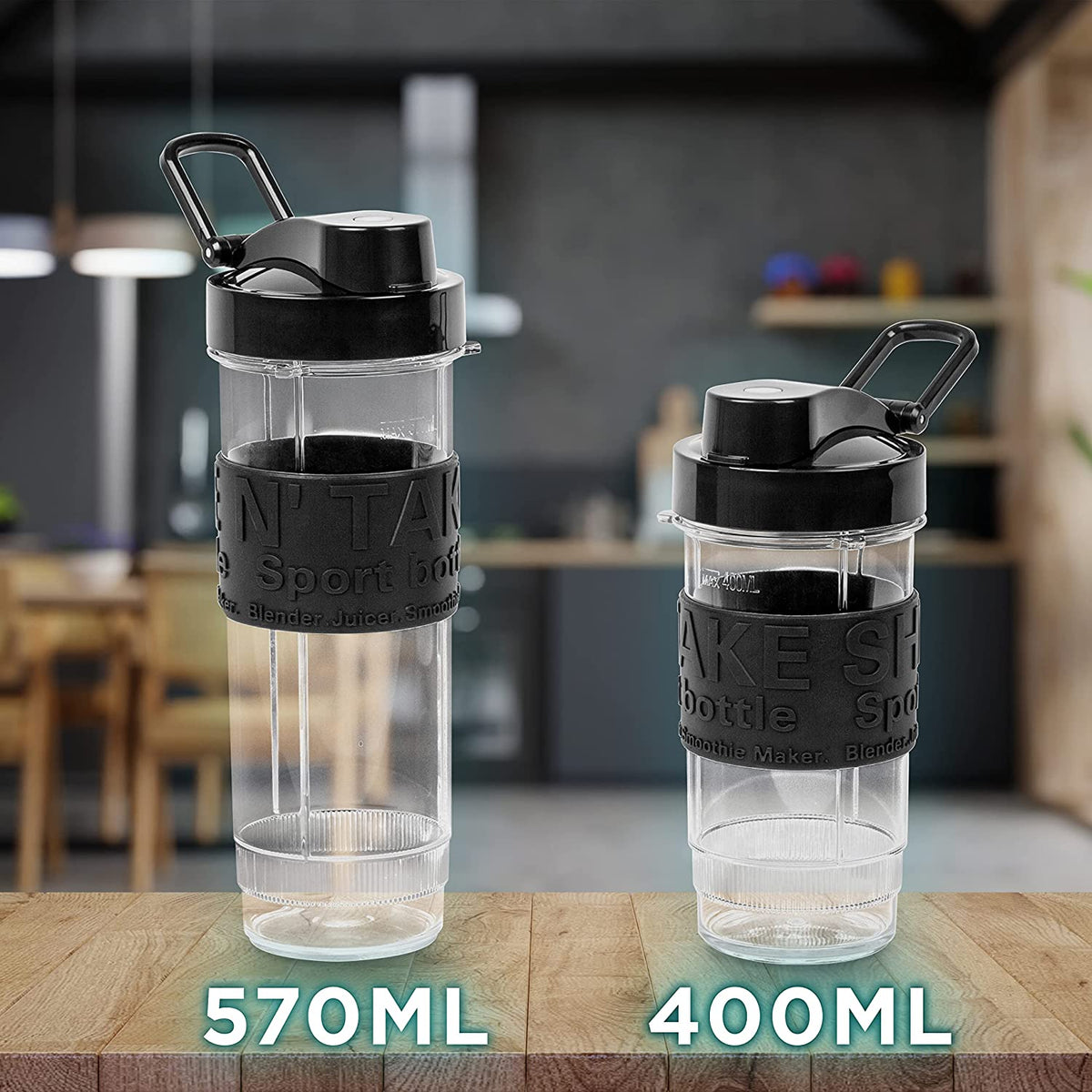 Duronic BL520 Mini Batidora de Vaso Individual 500W | Mostrando las dos botellas portátiles de Tritan libres de BPA incluidas con la batidora, una grande de 570 ml a la izquierda y una pequeña de 400 ml a la derecha, ambas con tapas negras antiderrame, asa de transporte y una banda de goma antideslizante con textura, colocadas sobre una superficie de madera con una cocina difuminada de fondo