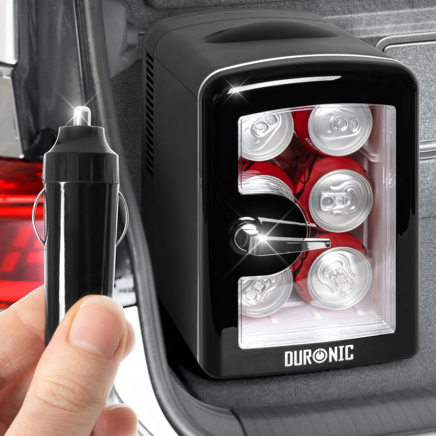 Duronic MFW4 BK Mini Nevera 4L 42W Frigorífico Portátil Mostrando la mini nevera instalada en el maletero de un coche, conectada mediante su adaptador de corriente para vehículo, manteniendo latas de refresco frías durante el viaje