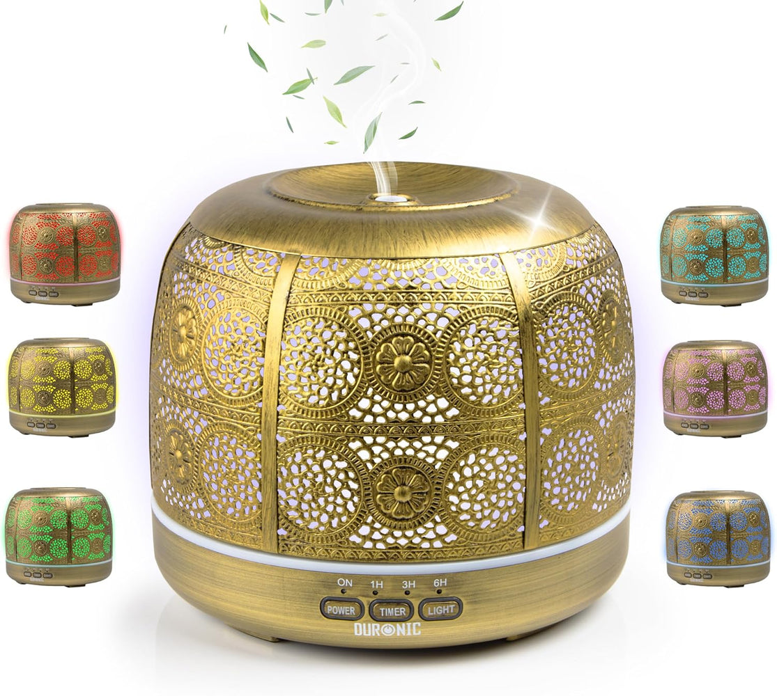 Duronic AD43 Difusor de Aromas y Brumizador de Aceites Esenciales Mostrando el difusor de aromaterapia de 500 ml en color dorado con carcasa metálica calada, expulsando bruma por la parte superior y rodeado de muestras de su iluminación LED ambiental en tonos rojo, amarillo, verde, turquesa, morado y azul, con los botones de control frontal POWER, TIMER y LIGHT.