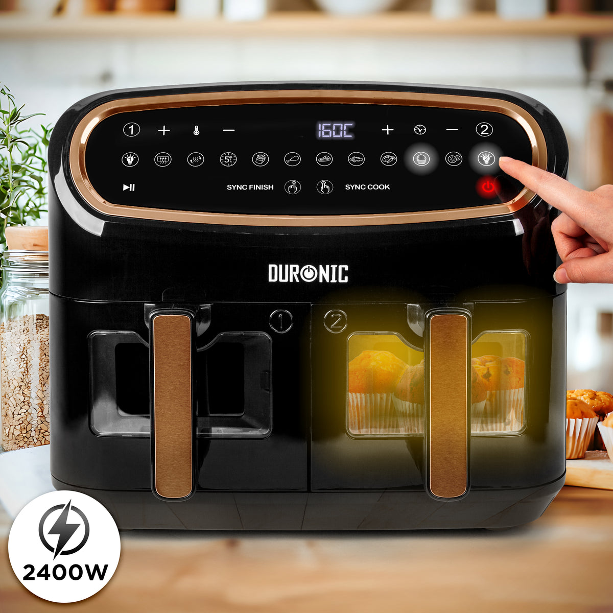 Duronic AF34 BG Freidora de aire sin aceite 2400 W | Mostrando la freidora de aire doble de color negro y bronce con la luz interior encendida en la cesta derecha para iluminar y visualizar los alimentos (como magdalenas) a través de su ventana transparente