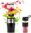 Duronic BL520 Mini Batidora de Vaso Individual 500W | Mostrando la mini batidora de vaso en funcionamiento con un vaso lleno de un batido de frutas rojo y verde, rodeada de salpicaduras de jugo, rodajas de fruta (granada, frambuesa, naranja, kiwi, plátano) y cubitos de hielo, junto a un vaso portátil adicional con asa y tapa a un lado