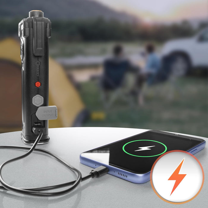 Duronic CT51, herramienta de emergencia para coche, conectada mediante cable USB-C a un teléfono móvil que se está cargando, en un entorno de camping al aire libre