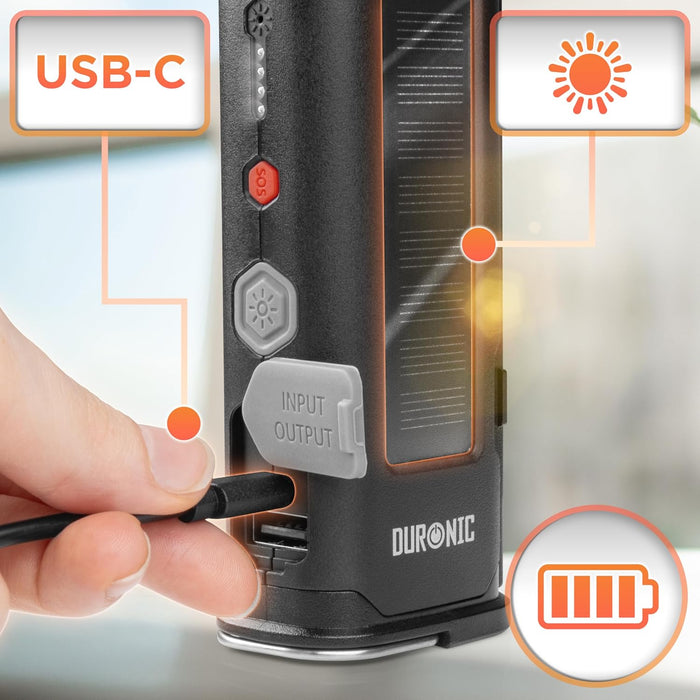 Duronic CT51, herramienta de emergencia para coche, mostrando una mano conectando un cable USB-C para cargarla, junto a su panel solar integrado para recarga solar