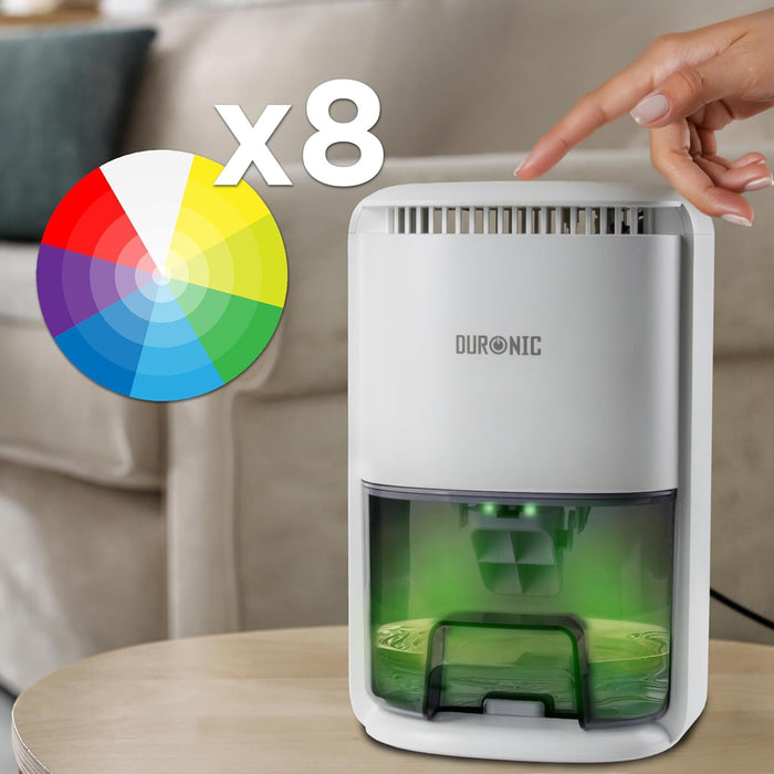 Duronic DH07 WE, deshumidificador eléctrico portátil, con el depósito iluminado en verde y una mano pulsando el botón superior, junto a una rueda de colores mostrando sus 8 opciones de iluminación LED