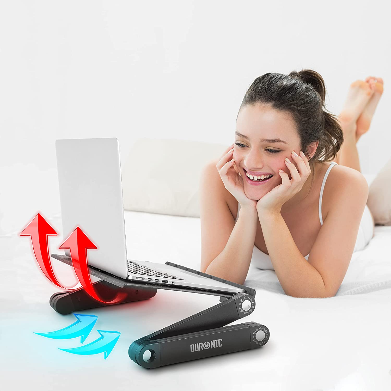 Duronic DML121 Soporte para Ordenador Portátil o Tablet Mostrando a una persona utilizando el soporte con un ordenador portátil mientras está acostada cómodamente en la cama