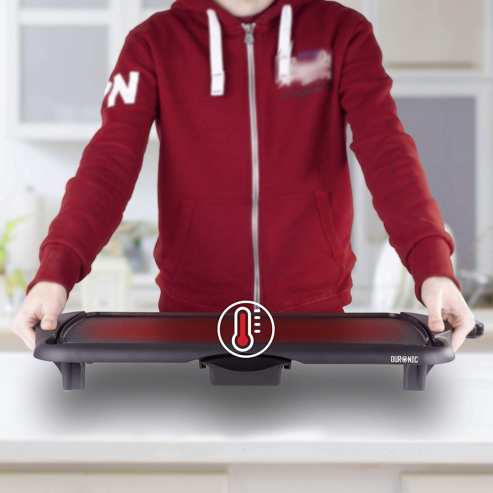 Duronic GP20 Plancha Eléctrica Grill Mostrando a una persona sosteniendo la plancha por sus asas laterales mientras se indica visualmente la distribución uniforme del calor en su superficie