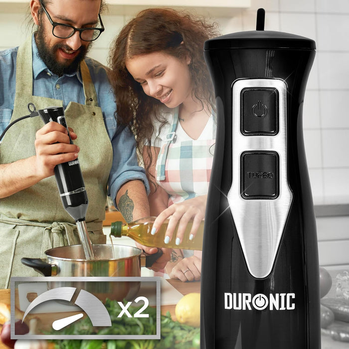 Duronic HB35B Batidora de Mano 350 W, 2 Velocidades, Ligera y Ergonómica Mostrando la batidora de mano Duronic HB35B en color negro, destacando sus 2 velocidades (indicadas por el icono x2 y sus botones de encendido y TURBO) mientras un hombre la utiliza en una olla con ayuda de otra persona que vierte aceite