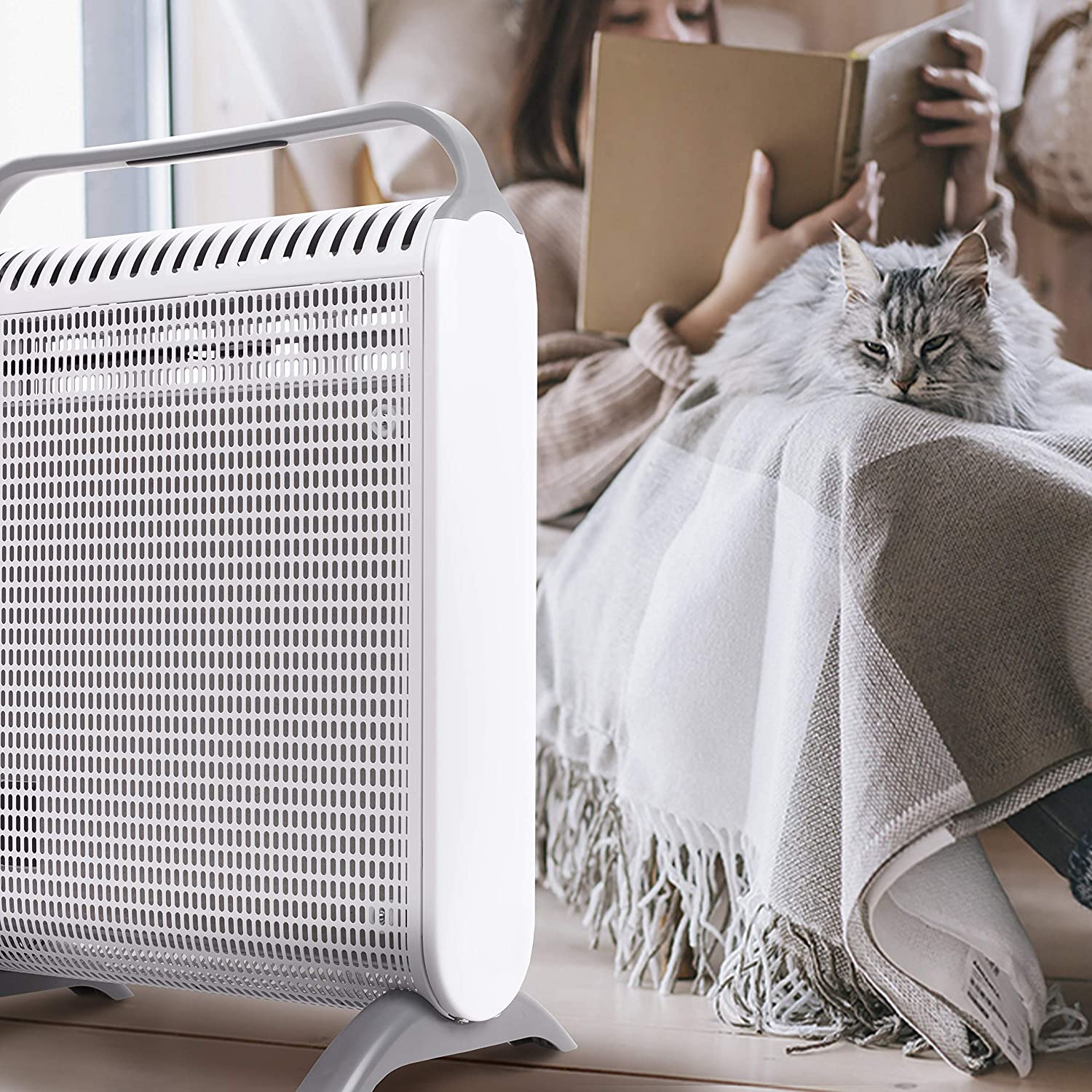 Duronic HV180 Radiador Eléctrico Compacto con Paneles de Mica 1800 W | Mostrando un primer plano del radiador de mica en color blanco y gris en un ambiente acogedor junto a una ventana, donde una persona lee un libro en segundo plano y un gato descansa plácidamente sobre una manta a cuadros